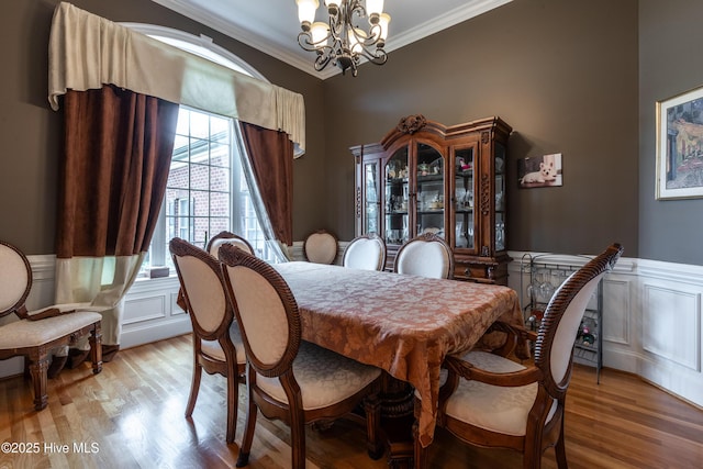404 River Birch Dr, Greenville, NC 27858 - dining area with a chandelier, crown molding, light wood finished floors, a wainscoted wall, and a decorative wall