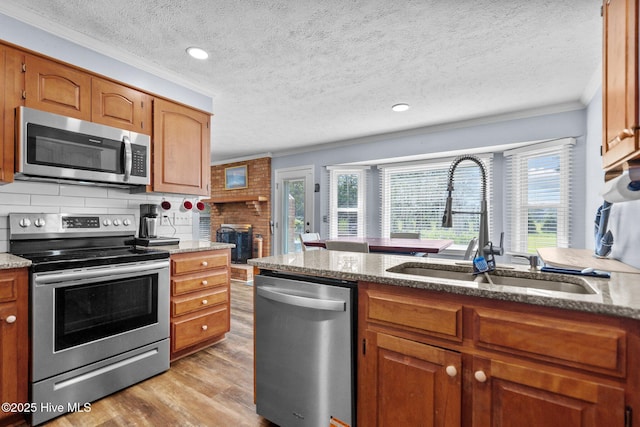 5023 Marathon Landing Ct, Castle Hayne, NC 28429 - kitchen featuring stainless steel appliances, crown molding, wood finished floors, plenty of natural light, and light stone countertops