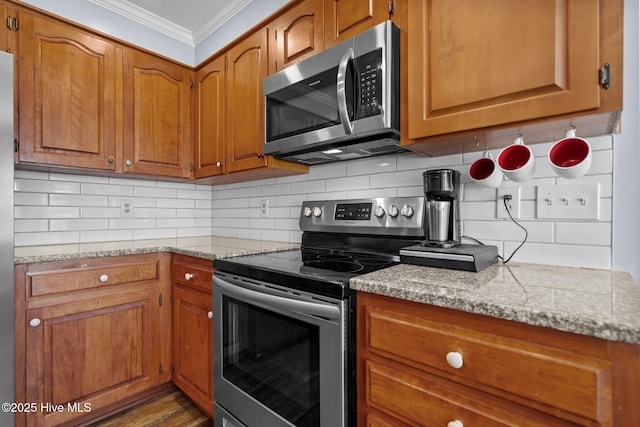 5023 Marathon Landing Ct, Castle Hayne, NC 28429 - kitchen featuring stainless steel appliances, ornamental molding, brown cabinets, tasteful backsplash, and light stone counters