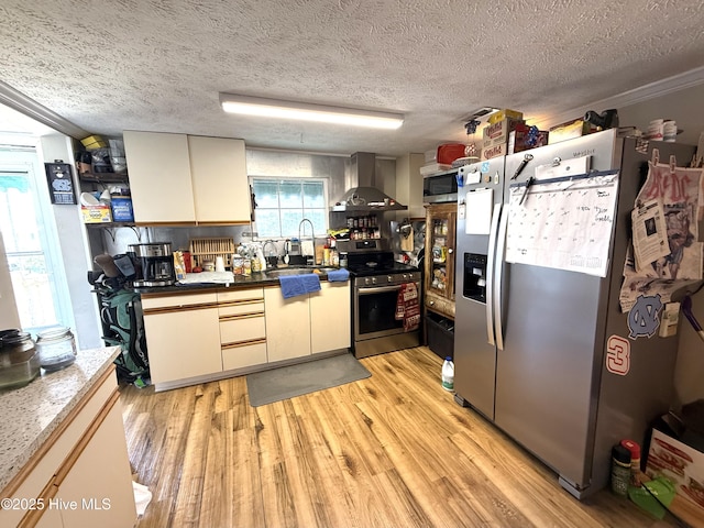 200 Carolina Beach Ave S, Carolina Beach, NC 28428 - kitchen featuring appliances with stainless steel finishes, wall chimney exhaust hood, light wood-type flooring, dark countertops, and a textured ceiling