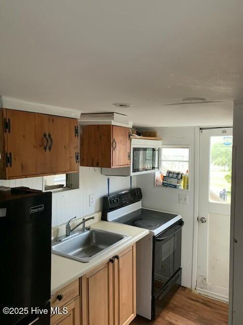 200 Carolina Beach Ave S, Carolina Beach, NC 28428 - kitchen with black / electric stove, fridge, light wood-style flooring, light countertops, and brown cabinets