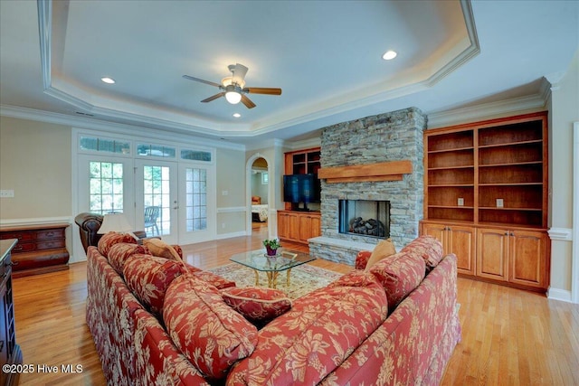 100 Knollwood Ct, New Bern, NC 28562 - living area featuring a raised ceiling, a ceiling fan, light wood-style floors, a stone fireplace, and french doors