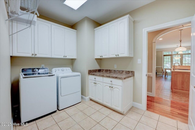 100 Knollwood Ct, New Bern, NC 28562 - washroom with cabinet space, independent washer and dryer, arched walkways, and light tile patterned floors