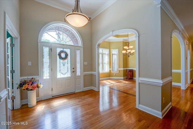 100 Knollwood Ct, New Bern, NC 28562 - foyer entrance featuring arched walkways, wood-type flooring, a chandelier, ornamental molding, and a towering ceiling