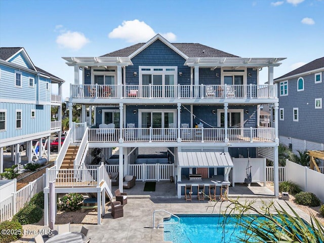 277 E Second St, Ocean Isle Beach, NC 28469 - rear view of house featuring a pergola, a fenced backyard, a patio, stairs, and a shingled roof