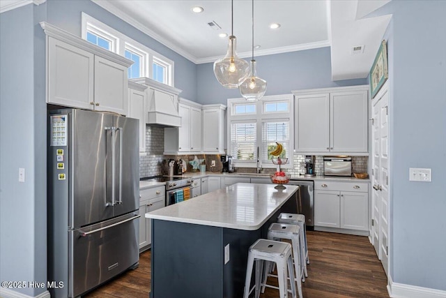 277 E Second St, Ocean Isle Beach, NC 28469 - kitchen with stainless steel appliances, dark wood-type flooring, crown molding, white cabinetry, and a center island