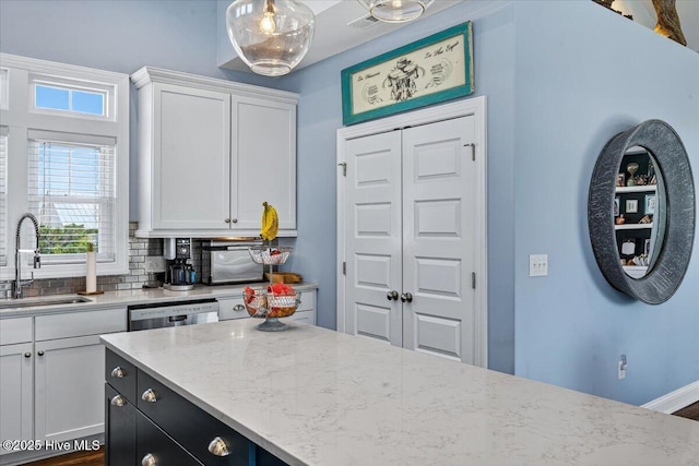 277 E Second St, Ocean Isle Beach, NC 28469 - kitchen featuring white cabinets, light stone counters, dishwasher, pendant lighting, and dark cabinets