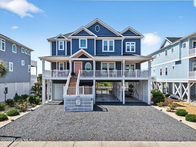 277 E Second St, Ocean Isle Beach, NC 28469 - coastal inspired home with driveway, an attached garage, a carport, stairway, and a porch