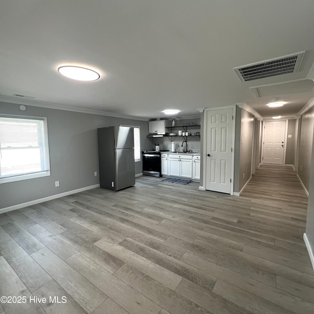 510 S Sycamore St, Fremont, NC 27830 - kitchen featuring freestanding refrigerator, light wood-type flooring, crown molding, light countertops, and open floor plan