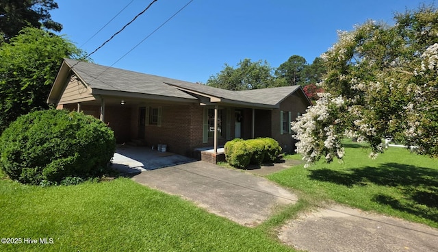 302 Bunche Dr, Goldsboro, NC 27530 - view of front of home with brick siding, an attached carport, a front yard, driveway, and covered porch