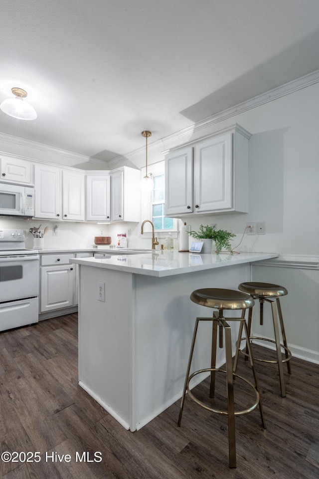 347 Stone Gate Dr, Greenville, NC 27858 - kitchen with white appliances, dark wood-style floors, crown molding, a peninsula, and white cabinetry