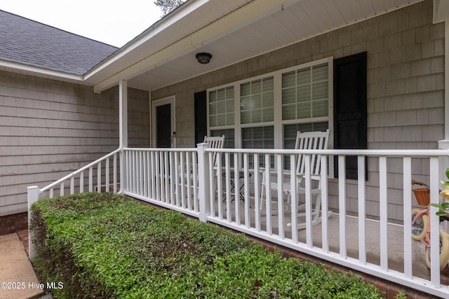 347 Stone Gate Dr, Greenville, NC 27858 - property entrance with roof with shingles and covered porch