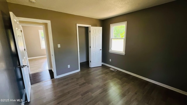204 Mercer St, Goldsboro, NC 27530 - unfurnished bedroom featuring dark wood finished floors, a closet, and a textured ceiling