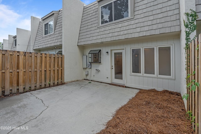 514 Cobblestone Dr, Wilmington, NC 28405 - back of house featuring mansard roof, a patio, and board and batten siding