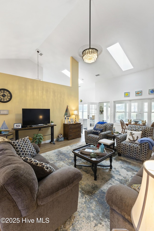 102 Crooked Gulley Cir, Sunset Beach, NC 28468 - living room featuring a skylight, wood finished floors, high vaulted ceiling, and a chandelier