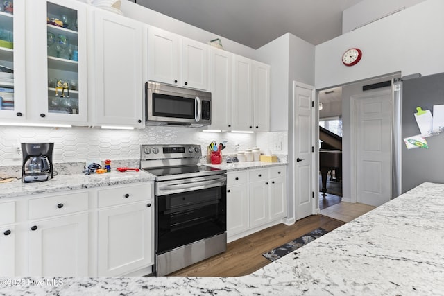 102 Crooked Gulley Cir, Sunset Beach, NC 28468 - kitchen featuring stainless steel appliances, dark wood finished floors, white cabinetry, and tasteful backsplash