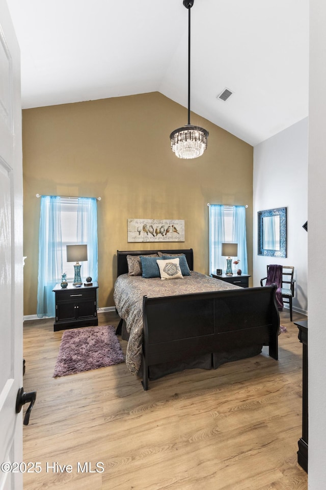 102 Crooked Gulley Cir, Sunset Beach, NC 28468 - bedroom with a chandelier, wood finished floors, and high vaulted ceiling