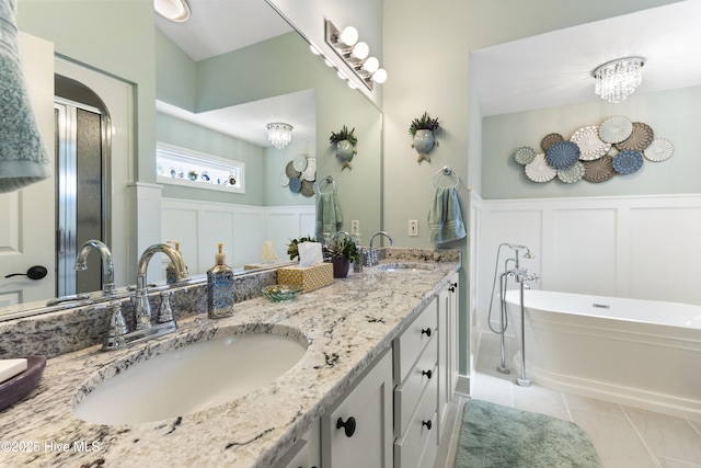 102 Crooked Gulley Cir, Sunset Beach, NC 28468 - bathroom featuring a decorative wall, a freestanding bath, double vanity, tile patterned floors, and a wainscoted wall