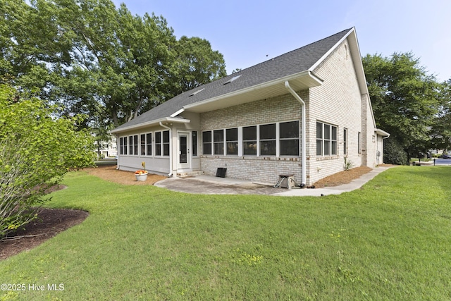 102 Crooked Gulley Cir, Sunset Beach, NC 28468 - rear view of house with a patio, a yard, brick siding, and a shingled roof