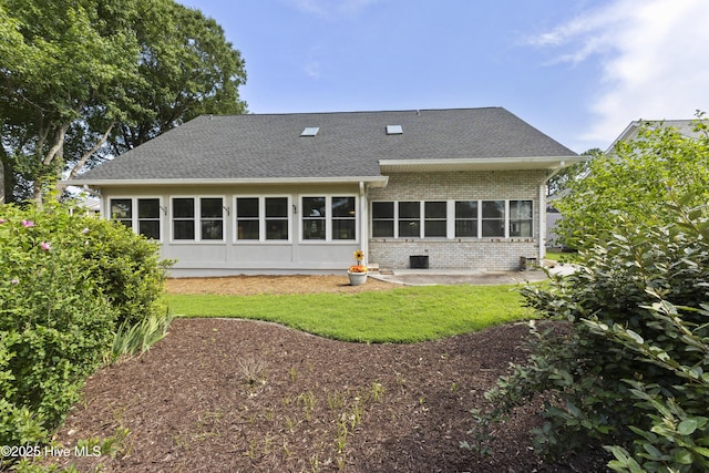 102 Crooked Gulley Cir, Sunset Beach, NC 28468 - back of house with brick siding, a shingled roof, and a yard