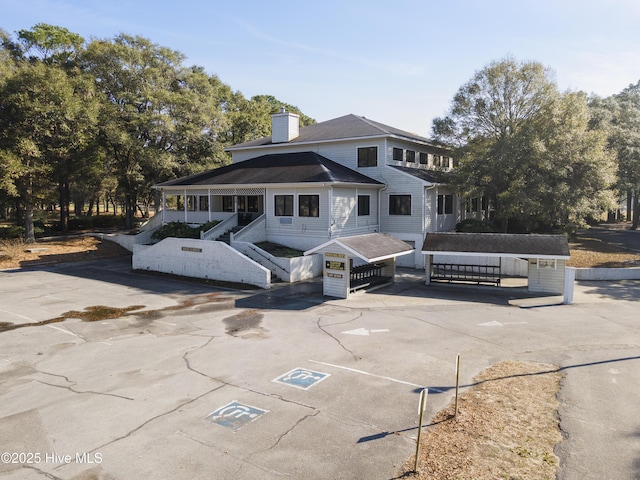 102 Crooked Gulley Cir, Sunset Beach, NC 28468 - view of front facade featuring stairway, a chimney, and covered porch