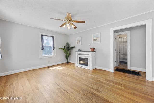 302 Roanoke Trl, Edenton, NC 27932 - unfurnished living room featuring ceiling fan, light wood-style flooring, a fireplace, and ornamental molding