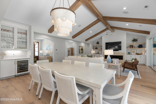 4139 Cobleskill Dr, Leland, NC 28451 - dining room with beverage cooler, a chandelier, light wood-style floors, bar area, and arched walkways
