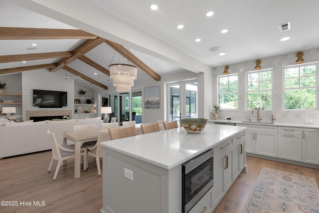4139 Cobleskill Dr, Leland, NC 28451 - kitchen featuring stainless steel microwave, a center island, light wood finished floors, recessed lighting, and open floor plan