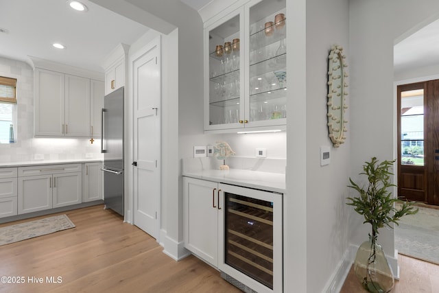 4139 Cobleskill Dr, Leland, NC 28451 - indoor dry bar featuring wine cooler, light wood-type flooring, high quality fridge, recessed lighting, and decorative backsplash