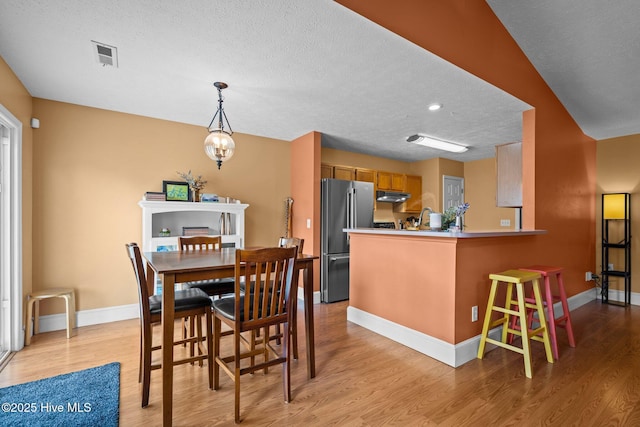 1005 Pleasant Dale Dr, Wilmington, NC 28412 - dining space with light wood-style flooring and a textured ceiling