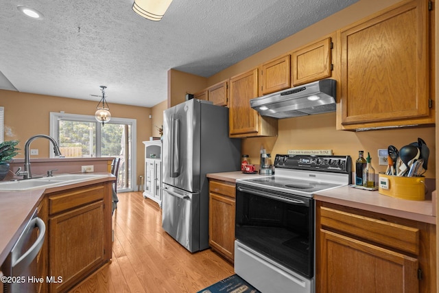 1005 Pleasant Dale Dr, Wilmington, NC 28412 - kitchen with appliances with stainless steel finishes, under cabinet range hood, light wood-style flooring, a textured ceiling, and hanging light fixtures