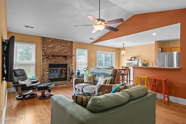 1005 Pleasant Dale Dr, Wilmington, NC 28412 - living room with vaulted ceiling, healthy amount of natural light, ceiling fan, light wood-style flooring, and a textured ceiling