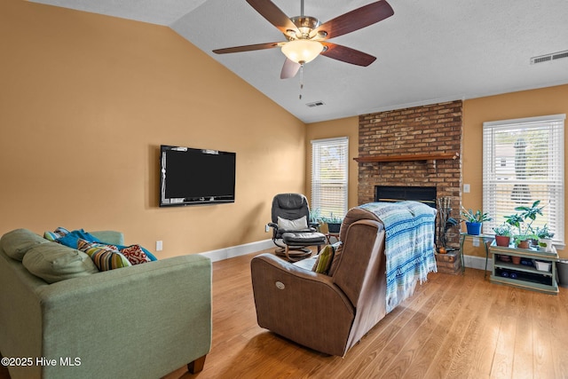 1005 Pleasant Dale Dr, Wilmington, NC 28412 - living area featuring light wood-style flooring, a ceiling fan, a brick fireplace, lofted ceiling, and a textured ceiling