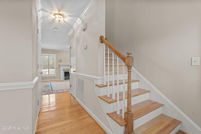 7405 Chickadee Ct, Sanford, NC 27332 - stairs with a textured ceiling, wood finished floors, and a fireplace