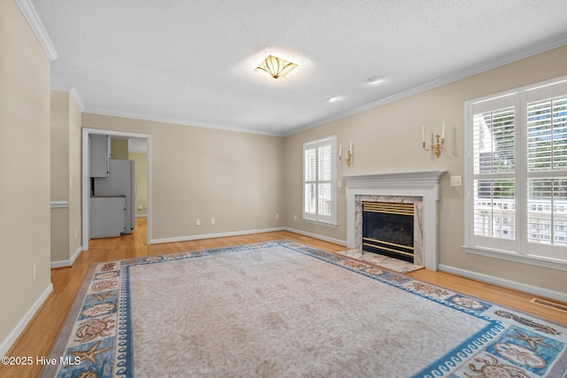 7405 Chickadee Ct, Sanford, NC 27332 - unfurnished living room featuring wood finished floors, ornamental molding, a textured ceiling, plenty of natural light, and a premium fireplace