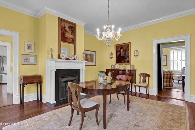 415 S 3rd St, Wilmington, NC 28401 - dining space featuring wood-type flooring, a fireplace with flush hearth, ornamental molding, and a chandelier