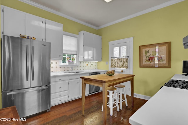 415 S 3rd St, Wilmington, NC 28401 - kitchen featuring freestanding refrigerator, dishwashing machine, light countertops, crown molding, and white cabinets