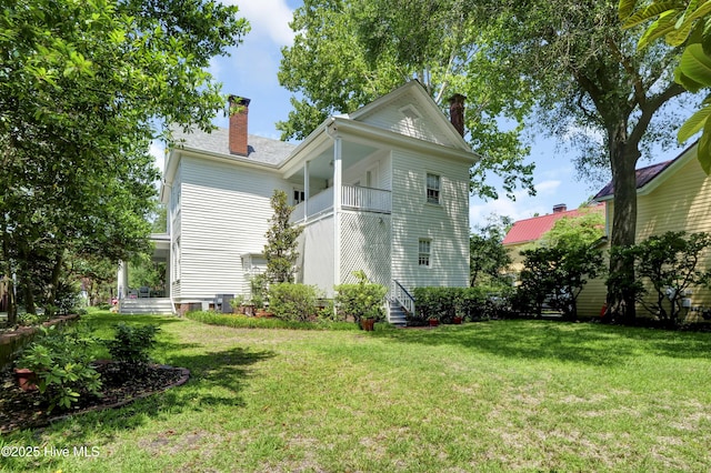 415 S 3rd St, Wilmington, NC 28401 - back of house featuring a chimney, a balcony, and a lawn