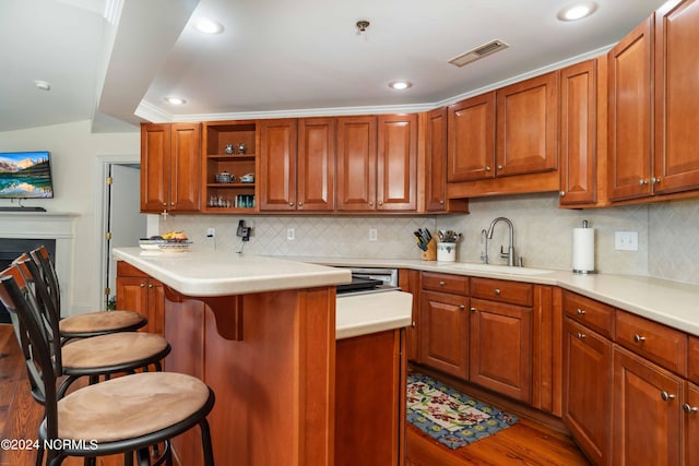 300 Midyette St Unit A15, Oriental, NC 28571 - kitchen featuring a breakfast bar area, light countertops, wood finished floors, decorative backsplash, and open shelves