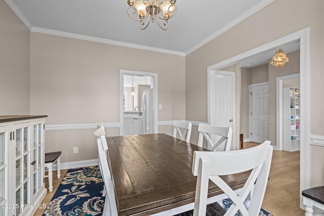 324 Foster Creek Rd, Swansboro, NC 28584 - dining space with a chandelier, crown molding, and light wood finished floors