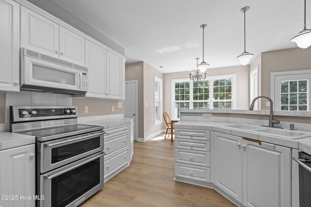 324 Foster Creek Rd, Swansboro, NC 28584 - kitchen featuring stainless steel appliances, white cabinetry, light wood-type flooring, and a chandelier
