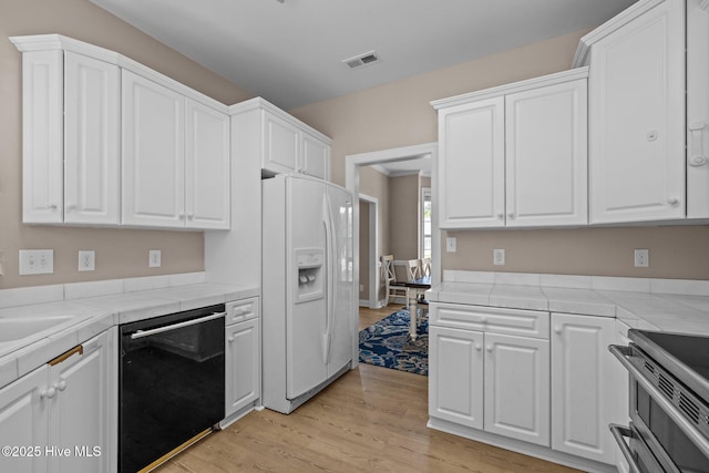 324 Foster Creek Rd, Swansboro, NC 28584 - kitchen featuring dishwasher, white fridge with ice dispenser, tile countertops, and white cabinets