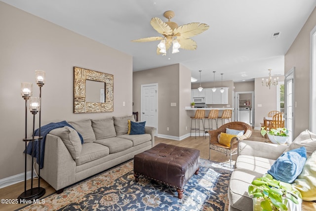 324 Foster Creek Rd, Swansboro, NC 28584 - living area featuring a chandelier, light wood-style floors, and a ceiling fan