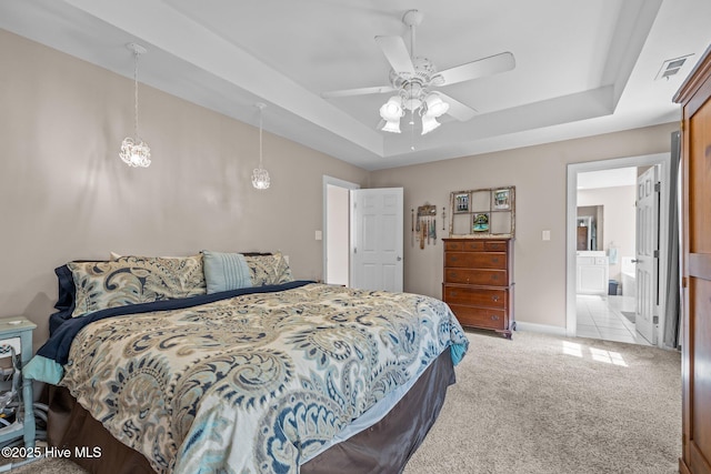 324 Foster Creek Rd, Swansboro, NC 28584 - bedroom featuring a tray ceiling, light carpet, ensuite bath, and a ceiling fan