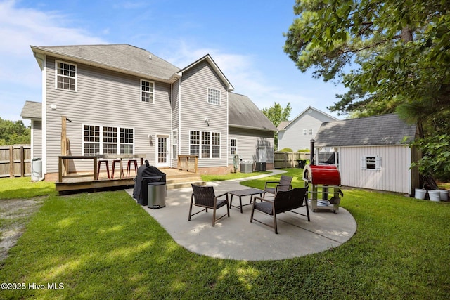 324 Foster Creek Rd, Swansboro, NC 28584 - rear view of property featuring a fenced backyard, a deck, a patio area, and a storage unit