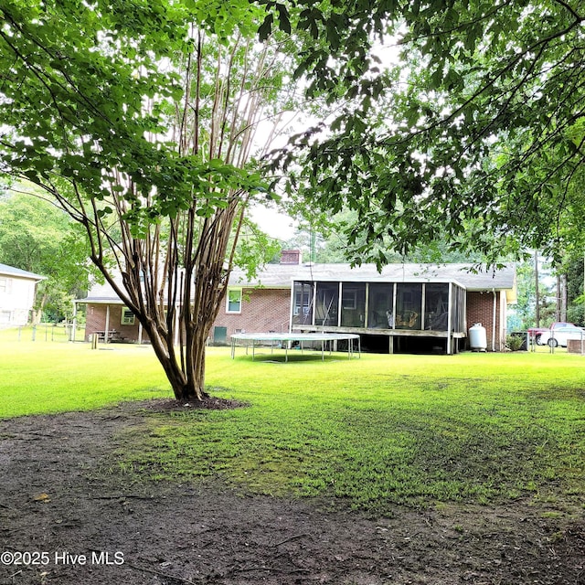 204 Tyree Rd, Kinston, NC 28504 - rear view of property with brick siding, a yard, and a sunroom