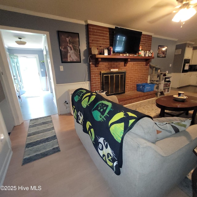 204 Tyree Rd, Kinston, NC 28504 - living room with ornamental molding, light wood-style flooring, wainscoting, a fireplace, and a ceiling fan