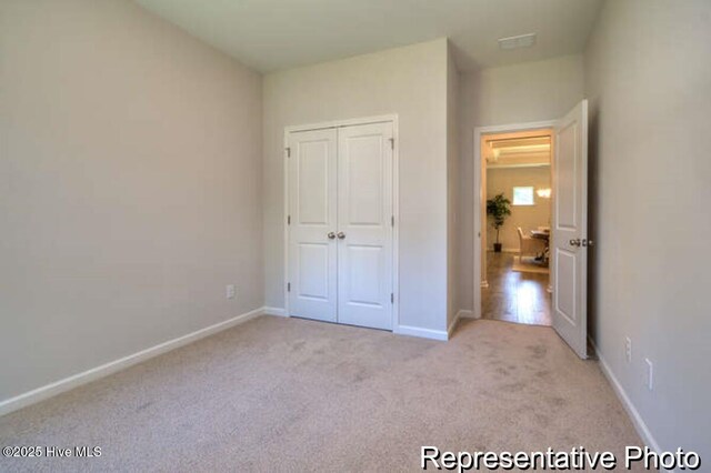 120 Forest Walk SW Unit 73, Sunset Beach, NC 28468 - unfurnished bedroom featuring light carpet and a closet