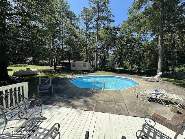 12760 S Pine Villa Dr, Laurinburg, NC 28352 - outdoor pool featuring a storage shed, view of wooded area, and a wooden deck