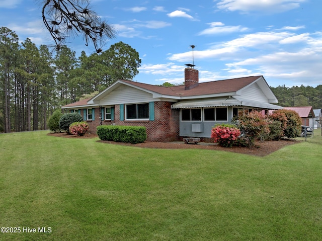 377 Louis Breeden Blvd, Hamlet, NC 28345 - rear view of house featuring a yard, a chimney, and brick siding